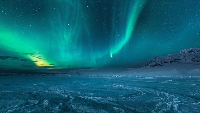 Dancing northern lights over arctic ice plain with circular track marks under starry sky