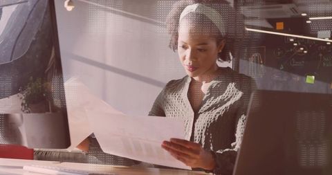 Professional Woman Analyzing Financial Documents in Modern Office