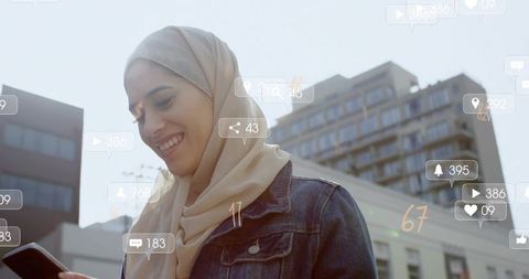 Hijab woman checking smartphone with social media notifications on urban street