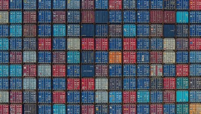 Stacking multicolor shipping containers forming geometric grid in port yard for world freight