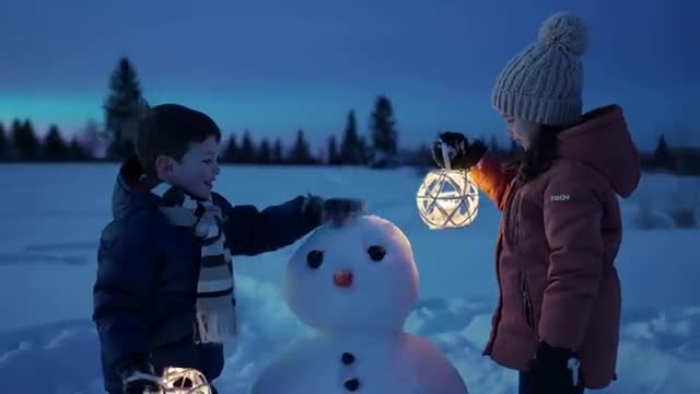 Kids Holding Lanterns with Snowman During Twilight