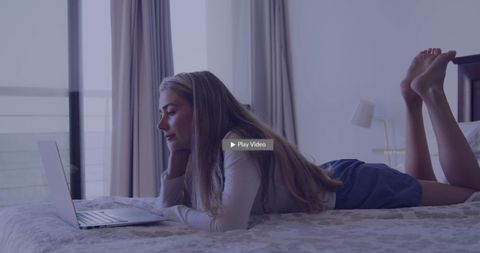 Young Woman Relaxing on Bed Browsing Laptop