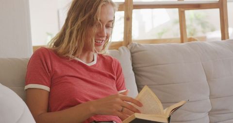 Woman Reading Book on Sofa at Home for Relaxation and Leisure