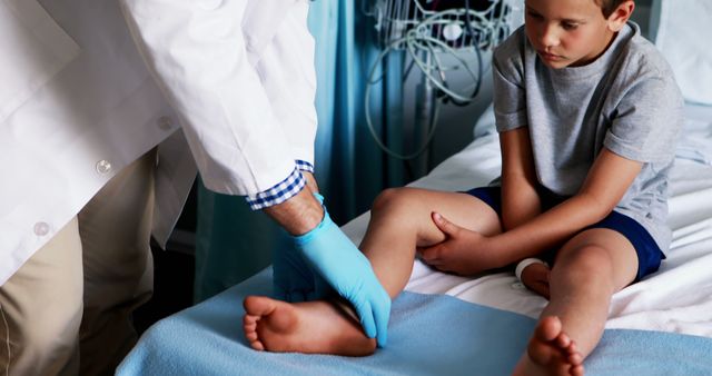 Doctor Examining Young Boy's Leg for Injuries in Hospital Bed - Download Free Stock Images Pikwizard.com