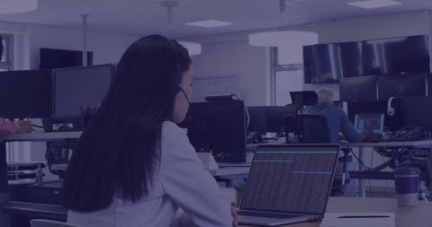 Businesswoman analyzing data on laptop in modern office environment