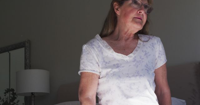 Elderly Woman Sitting on Bed Contemplating - Download Free Stock Images Pikwizard.com