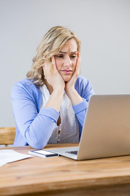 Stressed woman using laptop at home
