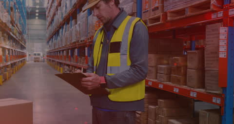 Warehouse Worker with Clipboard Conducting Inventory Checks in Storage Facility