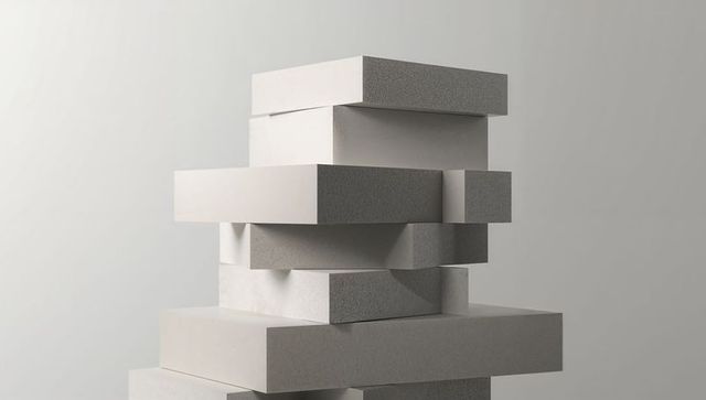 Stacking rectangular concrete blocks highlighting texture, geometry and dramatic shadows