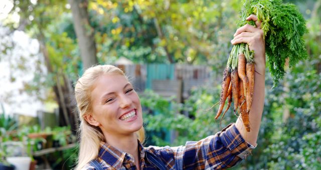Smiling Woman Holding Fresh Harvested Carrots in Garden - Download Free Stock Images Pikwizard.com