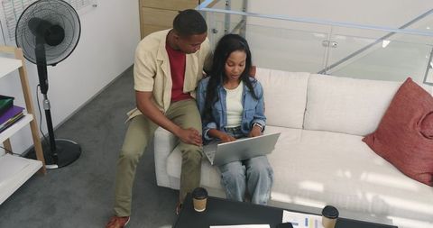 Colleagues Collaborating on Laptop in Modern Office Lounge