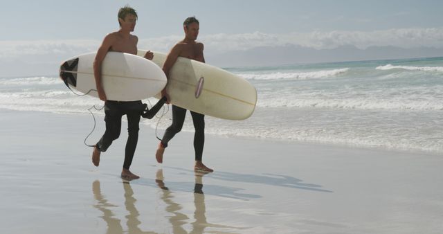 Surfers Running Along Beach with Surfboards - Download Free Stock Images Pikwizard.com