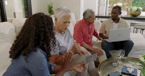 Diverse multigenerational family planning travel with passport and laptop in sunlit lounge