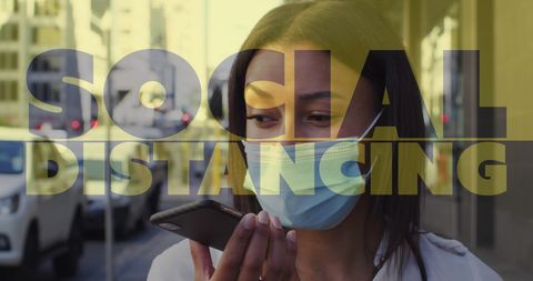 Masked woman speaking on smartphone on city street