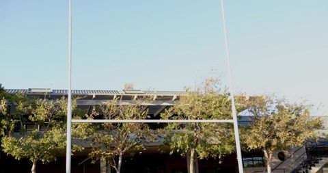 Framing tall white goalposts dominating stadium exterior with covered stands and canopy
