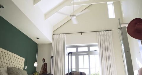 Modern bedroom with green accent wall and travelers' suitcase