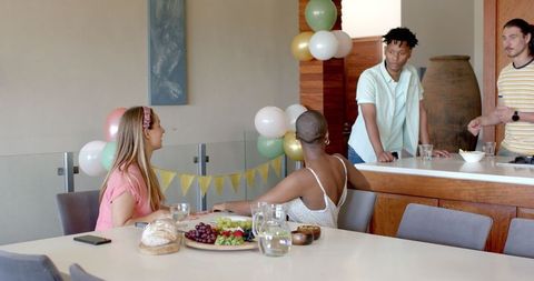 Friends Enjoying Snack-Filled Gathering at Home Celebration