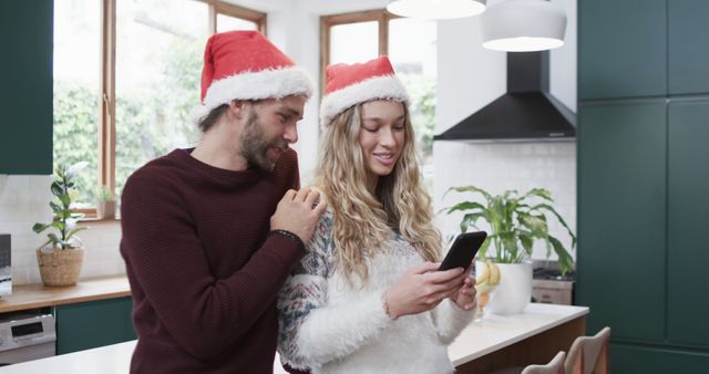 Happy Couple in Santa Hats Using Smartphone in Kitchen During Christmas - Download Free Stock Images Pikwizard.com