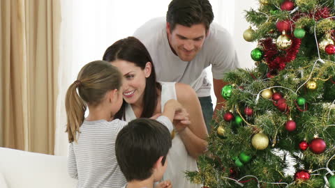 Family Creating Memories Decorating Christmas Tree