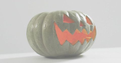 Glowing Carved Jack-O'-Lantern on High-Key White Tabletop Minimal Halloween Scene