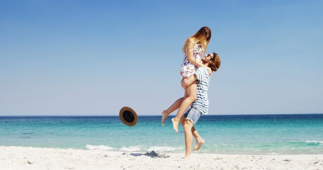 Young couple enjoying a sunny day at beach. Ideal for vacation promotions, romantic getaway advertisements, and travel blogs. Image can also be used for social media posts related to love, happiness, and summer activities.