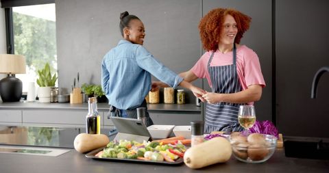 Happy Couple Dancing Together While Cooking in Modern Kitchen