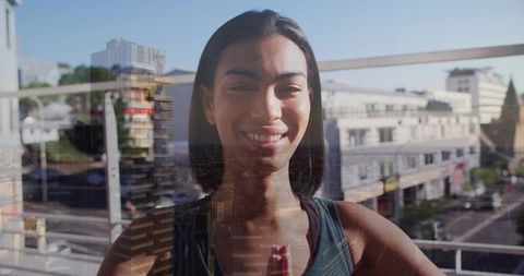 Smiling person practicing yoga on urban balcony with double exposure city skyline