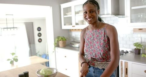 Smiling African American Woman Preparing Meal at Home Kitchen
