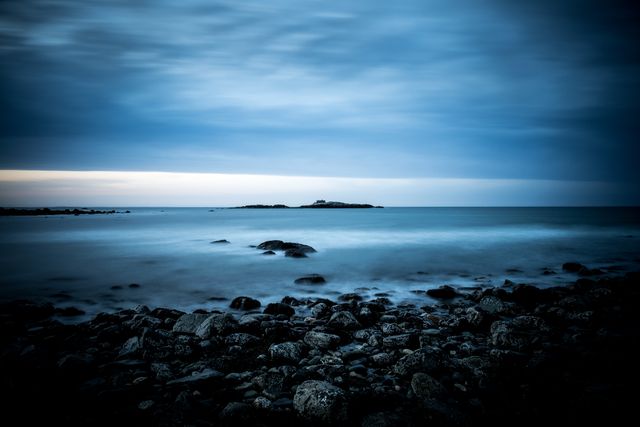 Tranquil Rocky Shoreline at Sunset Under Cloudy Sky - Download Free Stock Photos Pikwizard.com
