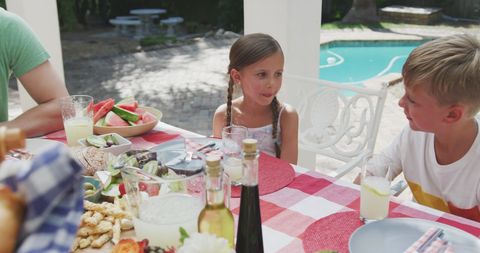 Children Relaxing by Poolside Table During Sunny Garden Gatherings - Download Free Stock Images Pikwizard.com