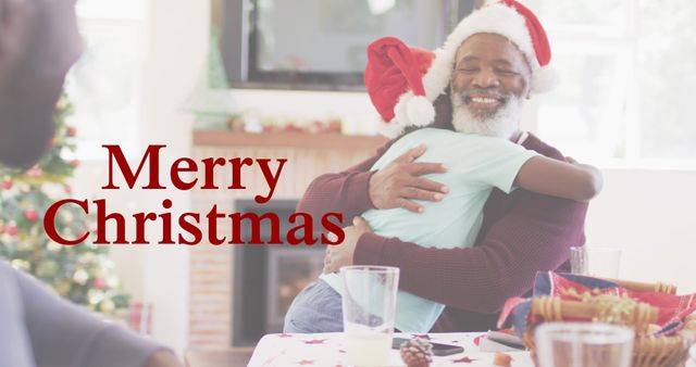 Merry christmas text banner against african american boy hugging his grandfather at home. christmas festivity and celebration concept