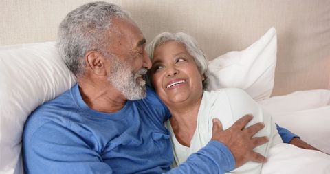 Senior Couple Embracing with Joyful Expressions in Bedroom