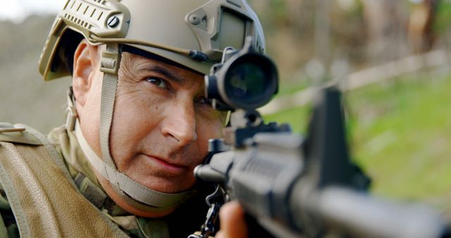 A close-up of an army soldier aiming with a military rifle. Dressed in full combat gear, including a helmet, the soldier is focused intently. This can be used to depict military operations, tactical training, armed forces, national defense promotions, or security service advertisements.