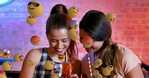 Friends Laughing Collectively Surrounded by Playful Emojis