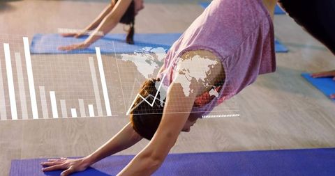 Woman practicing downward dog with augmented analytics overlay in modern group yoga class