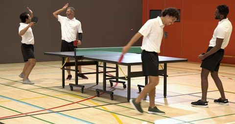 Diverse Male Team Celebrating at Gym Table Tennis Match
