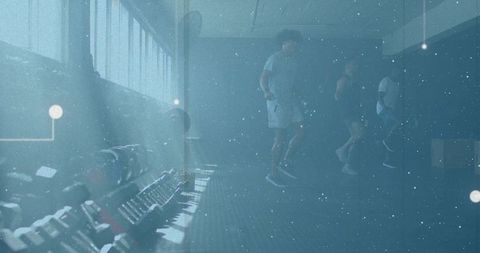 Three men training together in gym with dumbbell rack and moody blue lighting
