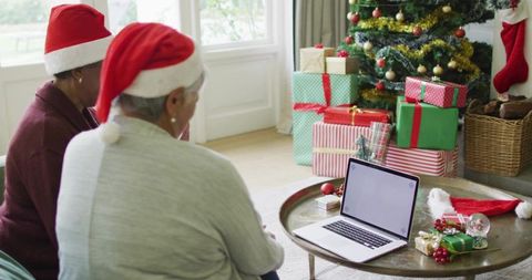 Seniors Wearing Santa Hats Sharing Laptop While Celebrating Virtual Family Christmas