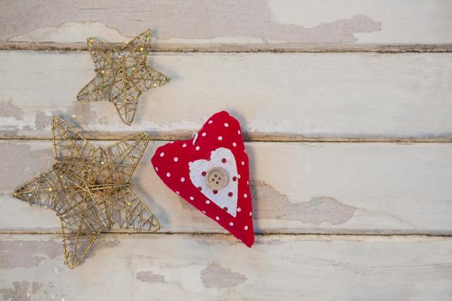Christmas star and heart decoration on rustic wooden plank. Ideal for holiday greeting cards, festive invitations, seasonal blog posts, and DIY craft inspiration. Perfect for adding a vintage touch to Christmas-themed projects and social media content.