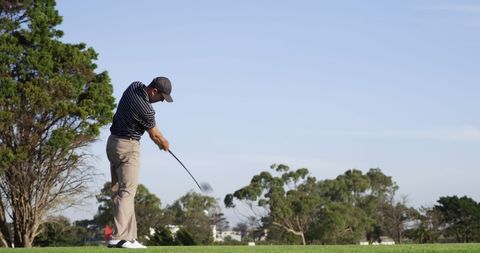 Golfer Perfecting Swing on Lush Green Course under Clear Sky - Download Free Stock Images Pikwizard.com