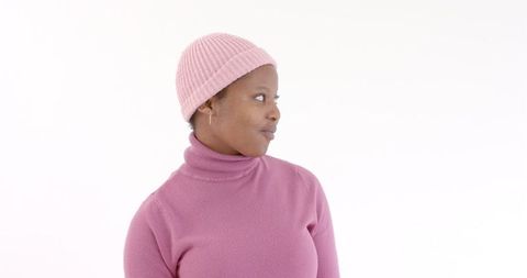 Woman in pink sweater and hat expressing curiosity