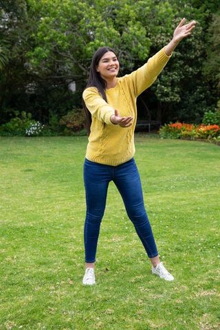 Cheerful woman in yellow sweater enjoying outdoor leisure