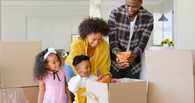 Parents and children unpacking boxes in a new home, symbolizing a fresh start and family unity. Useful for themes around family life, moving and relocation, homeownership, new beginnings, family bonding, and lifestyle articles.