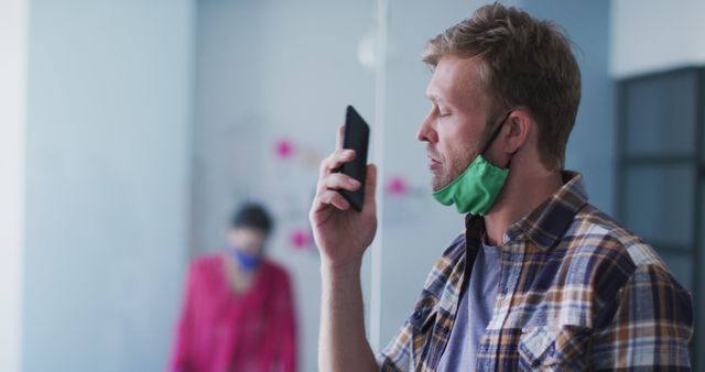 Man Wearing Mask Speaking on Smartphone in Office - Download Free Stock Images Pikwizard.com