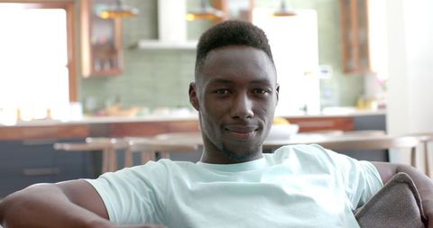 Confident Young Man Relaxing at Home in Bright Living Space