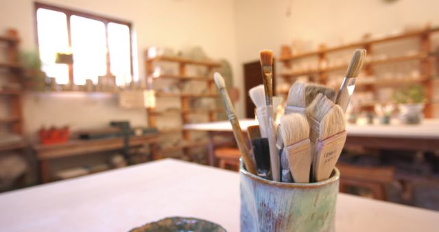 Brushes and pottery tools on desk in pottery studio. Pottery, ceramics, handmade, local business, hobbies and craft.