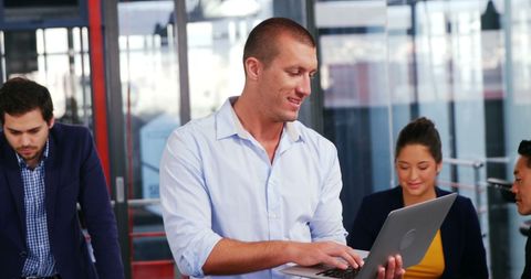 Business Executive Focused on Laptop in Modern Office