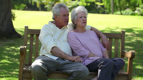 Senior Couple Relaxing on Park Bench in Peaceful Setting