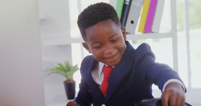A young African American boy in a suit is playfully engaging with an office chair, with copy space. His cheerful demeanor adds a touch of innocence and joy to the professional setting.