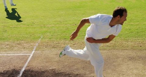 Action shot of cricketer bowling on sunny day